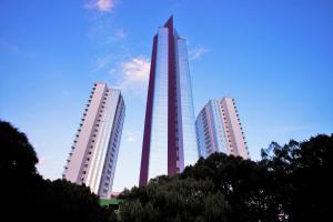 drei hohe Gebäude in einer Stadt mit einem Wolkenkratzer in der Unterkunft Hard Rock Hotel Guadalajara in Guadalajara