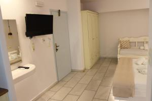 a bathroom with a tv on the wall and a sink at Vasilikos Studios in Naxos Chora