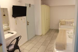 a bathroom with a table and a television in a room at Vasilikos Studios in Naxos Chora