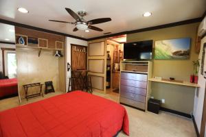 a bedroom with a red bed and a flat screen tv at Kaza Kokos in Oceanside