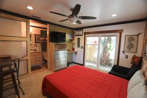 a bedroom with a red bed and a kitchen at Kaza Kokos in Oceanside