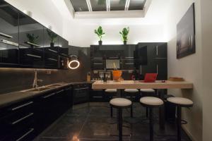 a kitchen with black cabinets and a counter with stools at full 4 floors house at the center in Antwerp