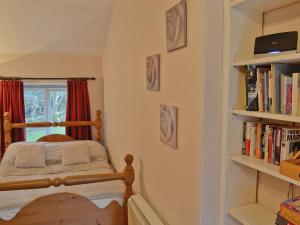 a bedroom with a bed and a book shelf at 1 Tan-y-castell in Dolwyddelan