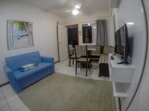 sala de estar con sofá azul y TV en BECO DOS MILIONÁRIOS, CANAJURÊ, en Florianópolis