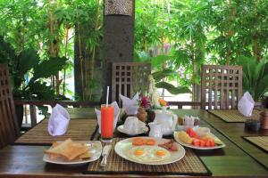 a table with breakfast foods and drinks on it at Alami Resort, Restaurant and Dive Center in Amed