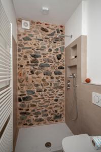y baño con ducha de piedra y pared de piedra. en Case Vacanza Skipper, en Pettenasco