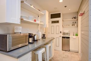 a kitchen with white cabinets and a counter top at Newly Renovated Whistler Studio in Whistler