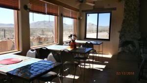 Casas Grandes的住宿－PUEBLO DEL SOuL at Paquime，用餐室设有桌椅和窗户。