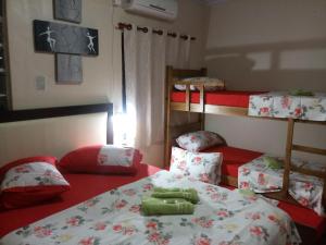 a bedroom with two bunk beds and red sheets at Pousada Leher in São Gabriel