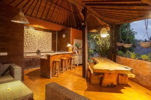 an outdoor kitchen with wooden tables and a bar at Pariliana in Ubud
