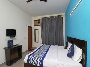 a bedroom with a large bed and a television at Hotel Akash Palace in Noida