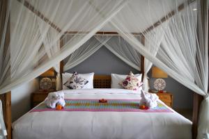 1 dormitorio con cama con dosel y animales de peluche en RC ubud villa en Ubud