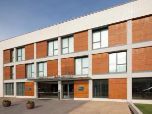 un edificio de oficinas con un cartel en la parte delantera en Hotel Ciutat Martorell en Martorell