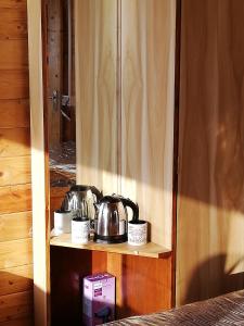 a shelf with two tea pots and cups on it at Red Crab Eco Resort in Cabo de Rama