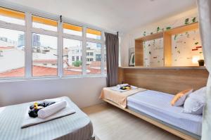 1 dormitorio con 2 camas y ventana en hipstercity hostel, en Singapur