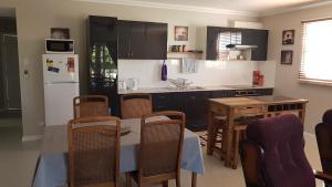 eine Küche mit einem Tisch und einem weißen Kühlschrank in der Unterkunft Sustainable B&B by the Bay in Brisbane