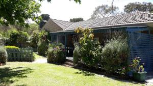 a house with a blue fence in a yard at VILLABAYVIEW SPACIOUS Stay in Rosebud