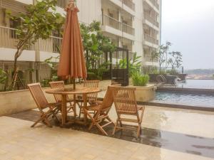 a table and chairs and an umbrella on a patio at Simply Studio Room at Annora Living Apartment Tangerang By Travelio in Tangerang