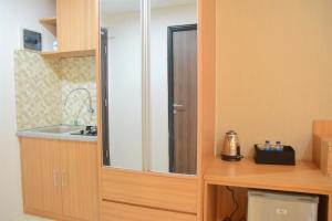 a kitchen with a sink and a mirror at Simply Studio Room at Annora Living Apartment Tangerang By Travelio in Tangerang