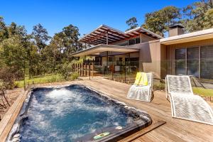 a swimming pool with two chairs and a house at Calanthe Acreage - Doonan in Doonan