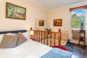 um quarto com uma cama e uma banheira em Bonnie Brae Cottage em Hepburn Springs