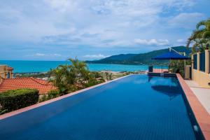 a swimming pool with a view of the ocean at Magnificence At Airlie in Airlie Beach