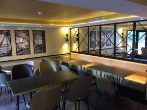 a dining room with tables and chairs and windows at Best Western Select Hotel in Boulogne-Billancourt