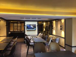 a restaurant with tables and chairs and a flat screen tv at Best Western Select Hotel in Boulogne-Billancourt