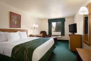 a hotel room with a bed and a television at Baymont by Wyndham Hearne in Hearne