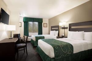 a hotel room with two beds and a desk at Baymont by Wyndham Hearne in Hearne