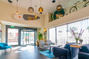 un salon avec une planche de surf au plafond dans l'établissement Roxon Sea Sand Bat Yam, à Bat Yam