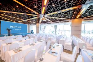 - une salle de réunion avec des tables et des chaises blanches dans l'établissement Hotel Novotel Nha Trang, à Nha Trang