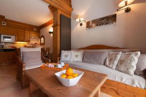 a living room with a couch and a table with a bowl of fruit at Résidence Le Cristal - Lognan 7 - Happy Rentals in Chamonix