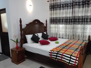 a bedroom with a bed with red and black pillows at Neo Grand Villa in Galle