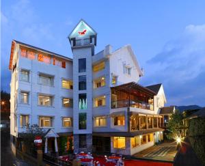 a large white building with a clock tower at Red sparrow in Munnar