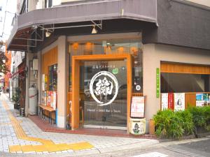 un magasin avec un panneau dans la fenêtre d'une rue dans l'établissement Hiroshima Hostel EN, à Hiroshima