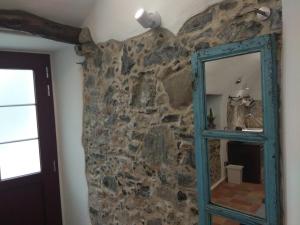 a mirror in a room with a stone wall at Le Ciappe Castelbianco Terra CITR 9020-BEB-0003 in Castelbianco