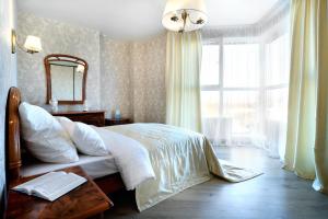 1 dormitorio con cama, espejo y ventana en PaulMarie Apartments on Yakubovskogo, en Mogilev