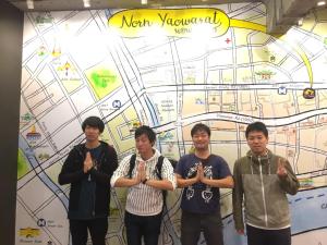a group of young men standing in front of a map at Norn Yaowarat Hotel in Bangkok
