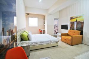 a bedroom with a bed and a chair and a television at Luxury Skopje Apartments Premium in Skopje