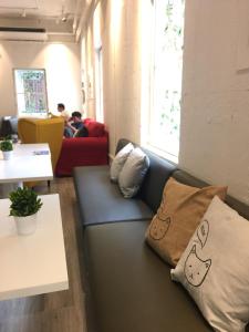 a couch in a room with pillows on it at Norn Yaowarat Hotel in Bangkok