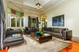 a living room with leather furniture and a table at Devonport Harbour View in Auckland