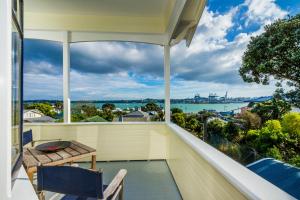 uma varanda com mesa e cadeiras e vista para a água em Devonport Harbour View em Auckland