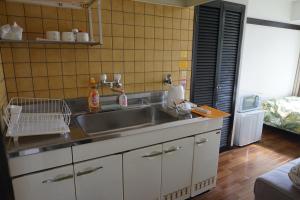 uma cozinha com um lavatório e uma bancada em CUBIC.30 em Hiroshima