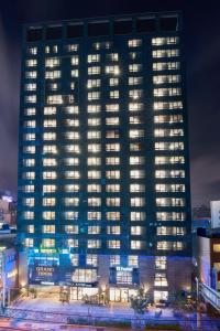 a tall building with lights in front of it at night at Hotel tt Seomyeon in Busan