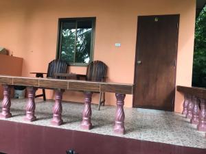 stół i krzesła przed budynkiem w obiekcie Pim Bungalow w mieście Mae Haad