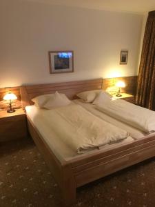 1 cama grande en un dormitorio con 2 lámparas en Landhaus Preißinger en Warmensteinach