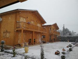 a house with a deck in the snow at Kastor Chalets in Ampelokipoi