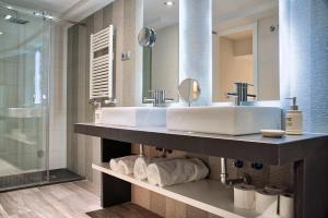 a bathroom with two sinks and a shower at Apartamentos Cava Baja in Madrid +157 photos