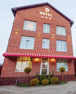 a red brick hotel with a sign on it at D Hotel in Krasnodar